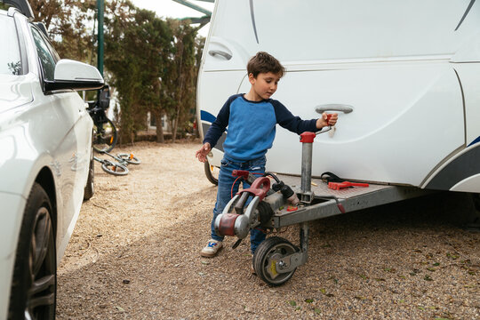 Boy helping with caravan hitch while camping