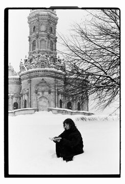 Film B&W Portrait of a Woman Sitting in Snow by Baroque Church