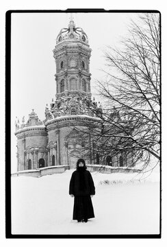 Film B&W Portrait of a Woman Before Baroque Church in Winter