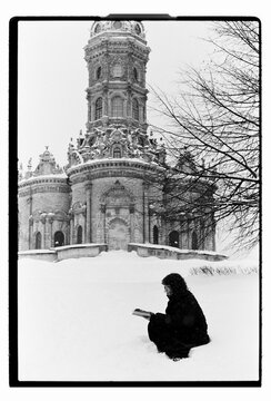 Film B&W Portrait of a Woman Sitting in Snow by Baroque Church