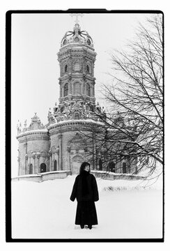 Film B&W Portrait of a Woman Before Baroque Church in Winter