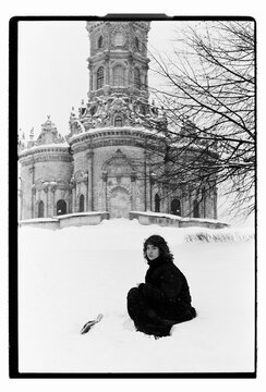 Film B&W Portrait of a Woman Sitting in Snow by Baroque Church