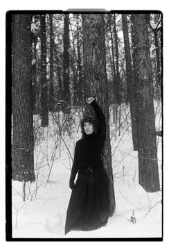 Film B&W Portrait of a Woman by Pine Tree in Snowy Forest
