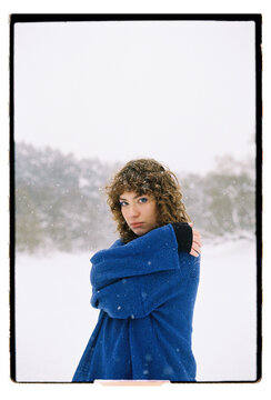 Film Portrait of a Woman in Blue Sweater Looking Over Shoulder in Snow