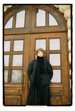 
Film Portrait of a Woman at Vintage Wooden Arched Door in Winter
