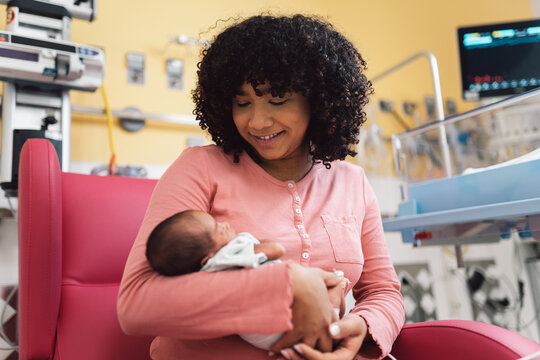 Mother holding newborn baby in hospital ward
