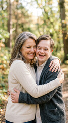 Fototapeta premium Loving senior mother and her adult son with Down syndrome sharing a warm hug outdoors, family bonding and inclusive lifestyle.