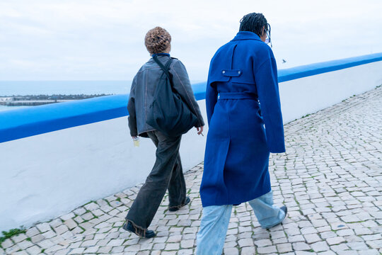 Two women having a walk in town by sea