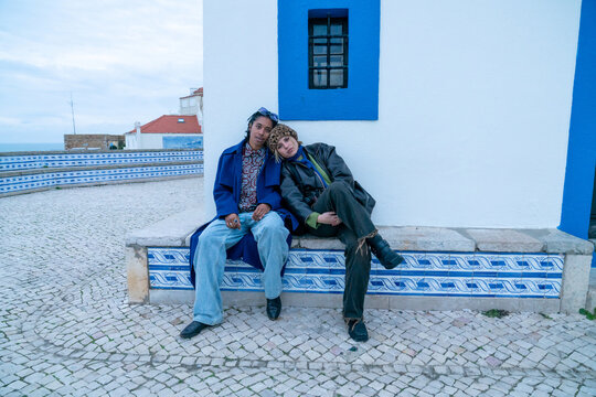 Two women sitting by a church bench 