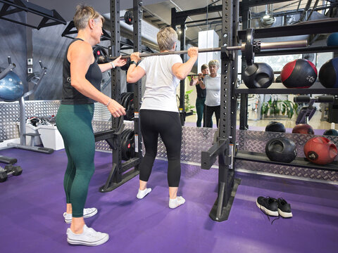 Women Lifting Weights at Gym in Workout Session During Daytime