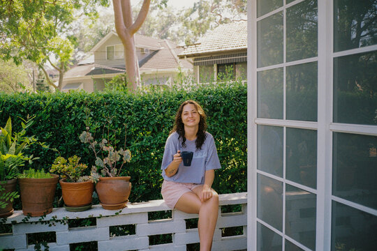 Woman has a cup of coffee in the garden