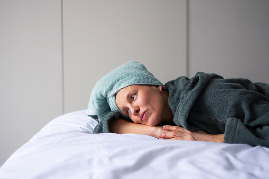 Woman Resting On Bed With Towel After Shower