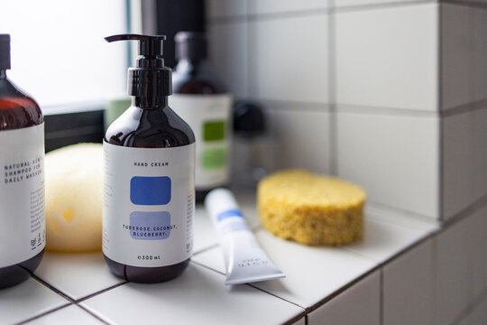 Hand Cream Bottle on Tiled Bathroom Shelf With Sponge
