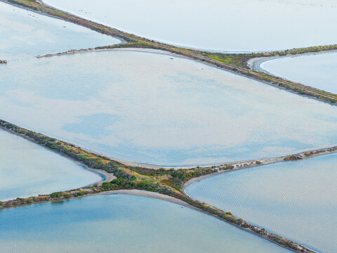 Cris cross patterns created by straight levee between in salt ponds