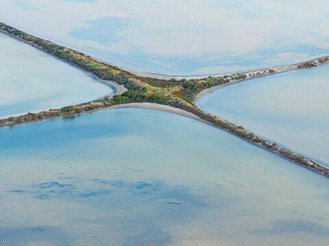 Cris cross patterns created by straight levee between in salt ponds