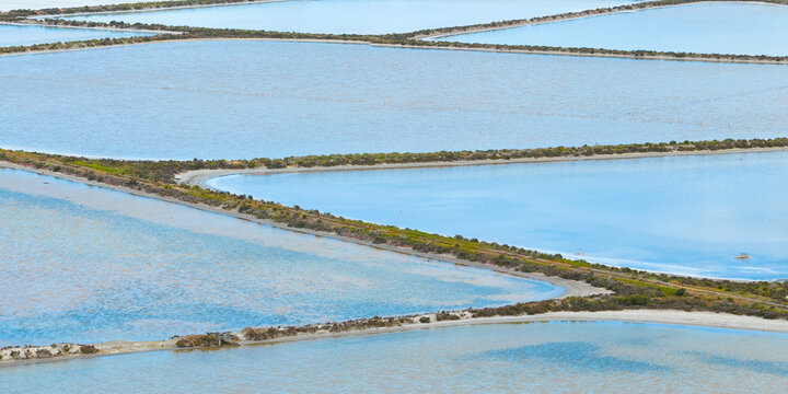 Abstract patterns created by straight levee between in salt ponds