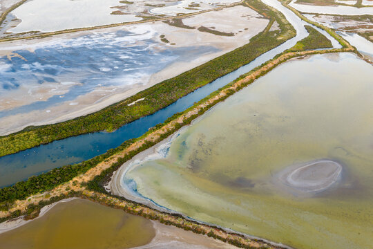 Narrow creek running between ponds at a coastal salt farm