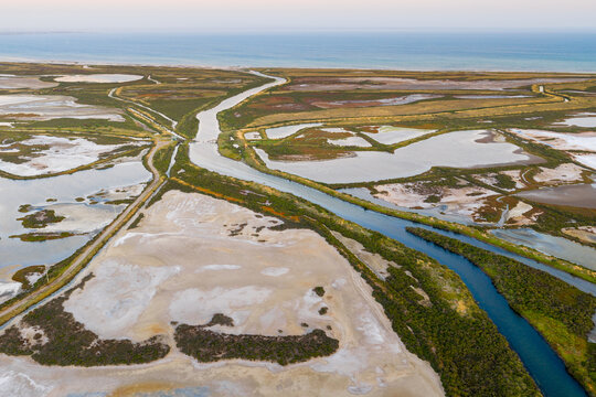 Narrow creek running between ponds at a coastal salt farm