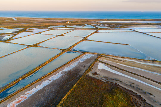 Multi colored ponds and levee bank payyerns in a coastal salt farm