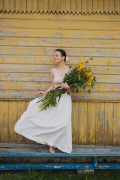 Woman holding big bouquet of yellow flowers.