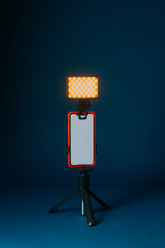 a lit led panel above a smartphone on a tripod