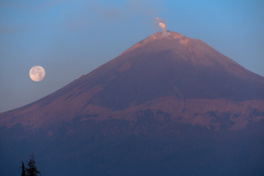 Full moon setting behind popocatepetl volcano in mexico