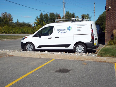 Nepean, Ontario, Canada &ndash; July 27, 2025: A white "Johnson Controls service van" with ladder racks and corporate branding is parked in an outdoor commercial parking lot on Antares Dr.