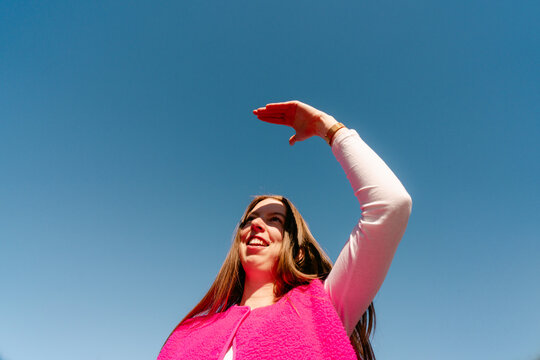 young woman with shielding her eyes from the sunshine 