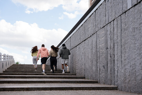Group running up outdoor stairs on a cloudy day