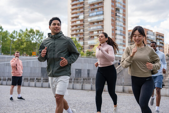 Group jogging together in city park on a cloudy day