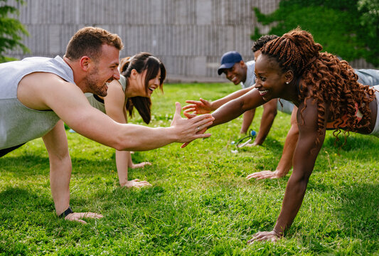 Group exercise in a park with people doing planks