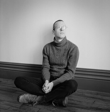 Portrait of a man sitting on a wooden floor