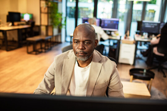 Focused businessman working at computer in modern open office