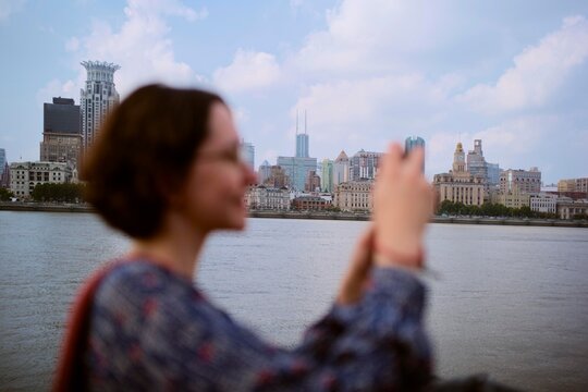 Tourist Takes Pictures of Shanghai City Skyline Near the River