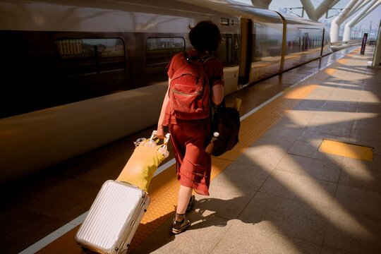 Traveling China by Train With Luggage in a Station