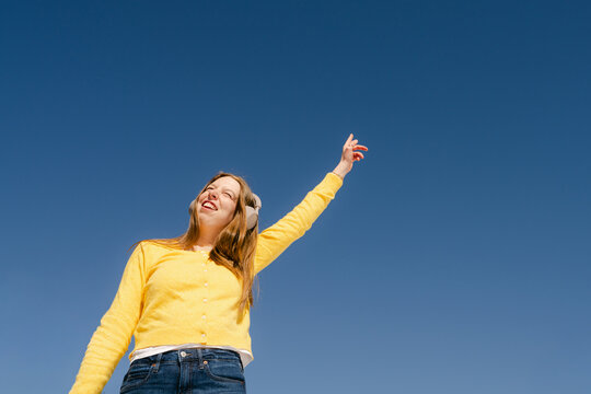 happy young woman listening and dancing  to music