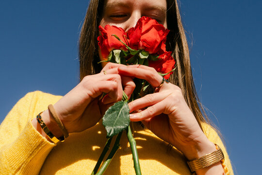 young woman smelling roses 
