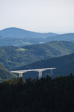 A modern bridge crossing a deep alpine valley 