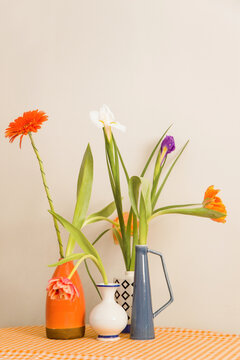 Colorful flowers in vases placed on a checkered tablecloth