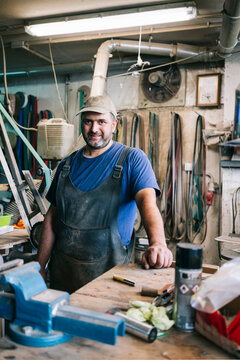 Craftsman working an apprenticeship in his busy workshop