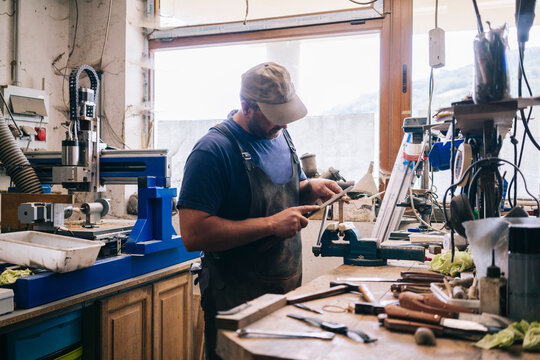 Craftsman making knife in workshop using hand tools