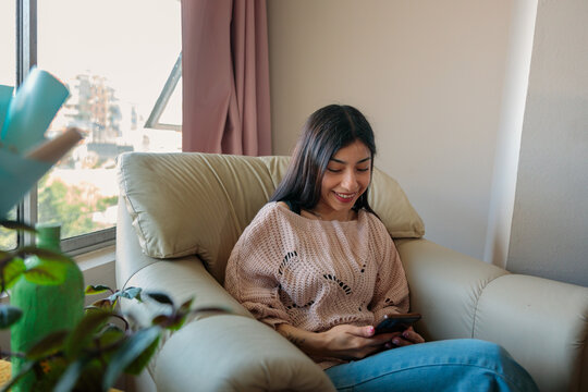 Young Woman Checking Smartphone at Home