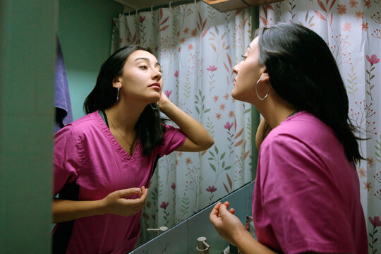 Healthcare Worker Checking Appearance in Bathroom