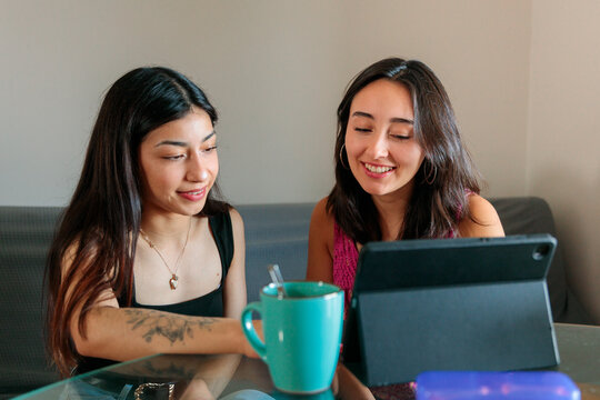 Female Friends Using Tablet While Studying