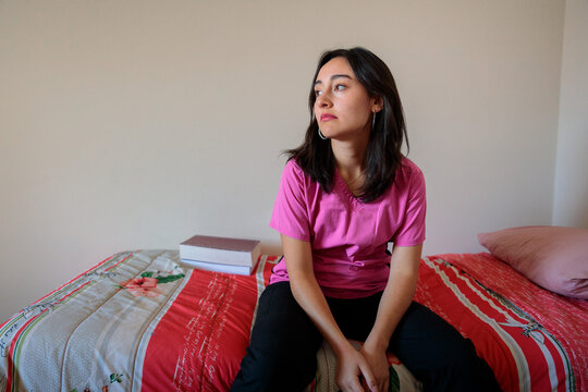 Tired Medical Student Sitting on Bed