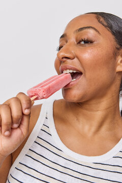 Woman eating a pink popsicle ice cream