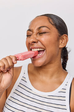 Woman eating a pink popsicle ice cream