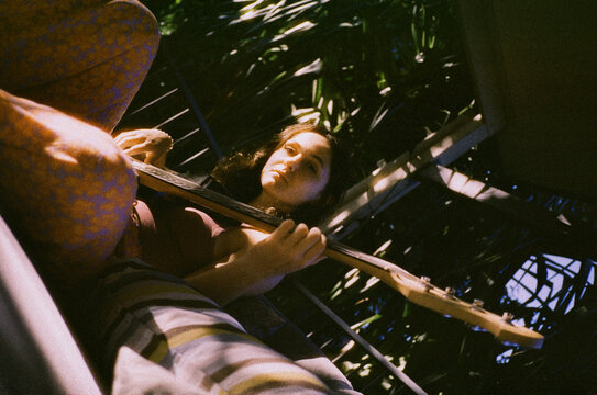 Woman playing bass guitar at home 