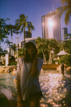 Woman standing at urban lagoon in Brisbane CBD at sunset 