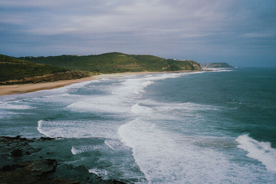 Rolling waves crash onto a sandy beach in Australia 